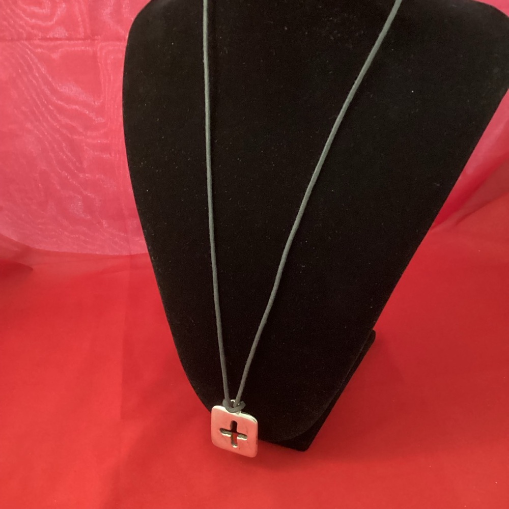 Silvertone cross on a black lace necklace